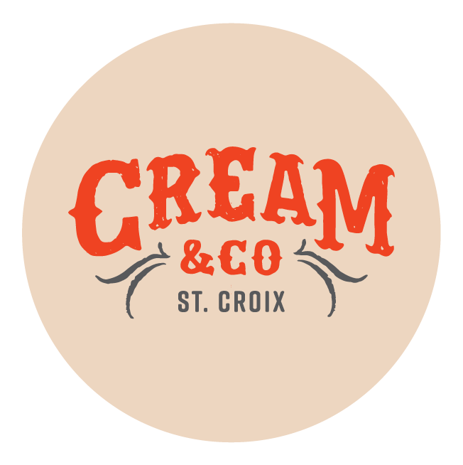 The image is a logo featuring the text "CREAM & CO ST. CROIX" in stylized red and gray fonts on a beige circular background.